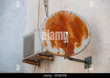 A close up view of a rusted satilite dish and airconditioning unit Stock Photo
