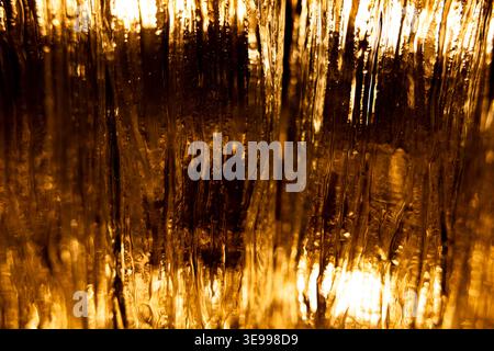 Abstract golden light through textured glass surface Stock Photo