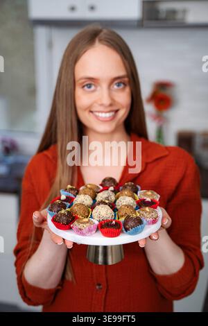 Woman holding tray of homemade holiday chocolate truffles Stock Photo
