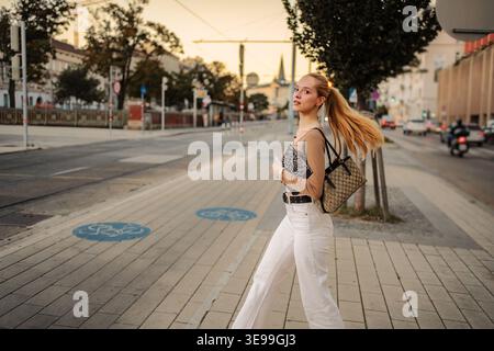Young woman walking across street in Vienna Austria Stock Photo