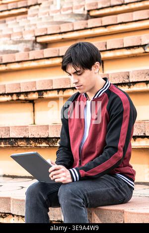 Young student learning outdoors using digital tablet Stock Photo
