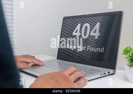 A man working on a laptop with website Page Not Found Error 404 on screen Stock Photo