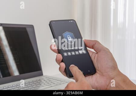 Two factor authentication OTP code for secure login. A man using a laptop and smartphone to log in by entering One Time Password code. Stock Photo