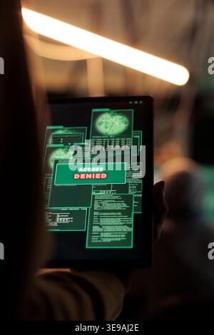Access denied message on digital tablet, hacker failed database hacking, unsuccessful password cracking. Cybercrime, internet criminal using malicious software, stealing data at night time Stock Photo
