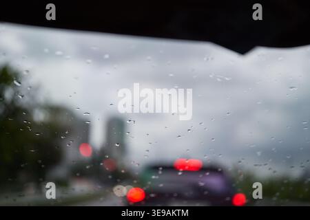 Distinct water droplets bead up on a treated glass surface. The blurred, moody background emphasizes the effectiveness of water-repellent coatings. Stock Photo