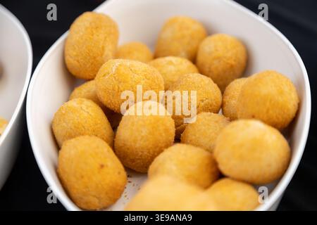 Delicious golden brown deep-fried potato croquettes or cheese balls served in a white ceramic bowl, a crispy appetizer or finger food snack perfect fo Stock Photo