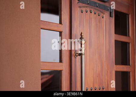 Side view of a decorative metal handle on a heavy wood panel door with iron studs Stock Photo