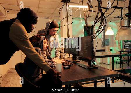 Team of encryption specialists trying to plant computer malware, fixing computer system cyberattack. Cyber criminals coding program script to break into network, cyberterrorism. Stock Photo