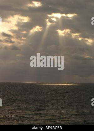 Dramatic crepuscular rays over the Pacific Ocean at sunset Stock Photo