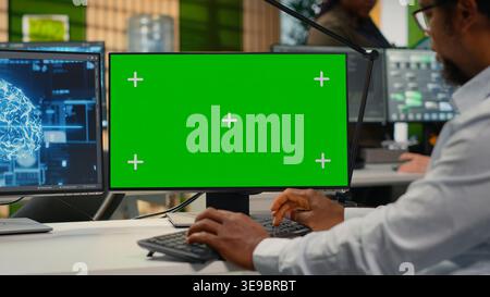 Green screen mockup PC used by data scientist in office automating workflows with artificial intelligence. IT worker refines deep learning models on chroma key computer for faster processing, camera B Stock Photo