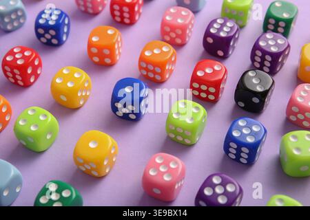 Colorful game dices on lilac background, closeup Stock Photo