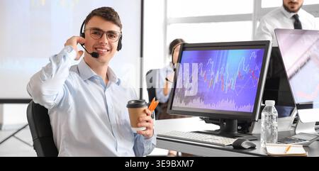 Male business analyst with coffee sitting at table in office Stock Photo