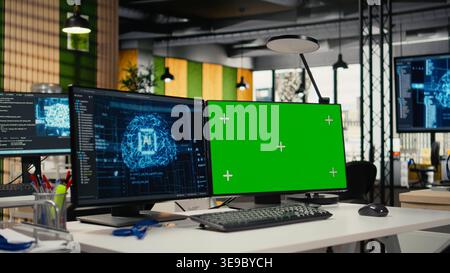 Green screen PC in empty startup office with artificial intelligence program running on monitors. Mockup computers in AI industry startup workspace leveraging deep learning tech enhancing automation Stock Photo