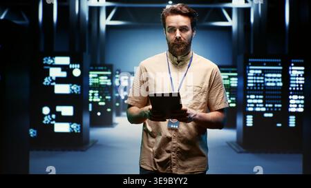 Computer scientist doing yearly checkup to extend data center electronics life span and avoid downtime. Experienced professional monitoring server infrastructure components Stock Photo