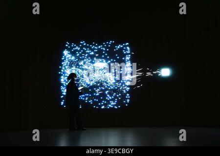 Programmer monitoring AI system cognitive flow using visual interface. IT professional studies real time activity of neural network nodes on digital wall to understand data processing algorithms Stock Photo