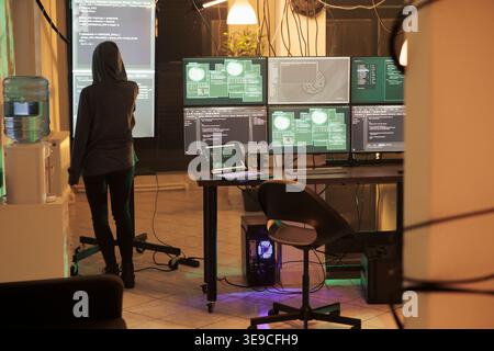 Young hacker analyzing script to crack security system and access network, trying to break into database. Spy planning computer malware and spyware, using virus to steal passwords. Stock Photo