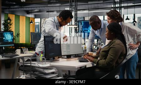 Team of technicians in office working together, automating workflows using AI. IT specialists collaborating to refine machine learning computational models for faster processing, camera A Stock Photo