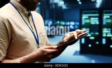 Computer scientist doing maintenance on VPN servers with high security standards used to adequately protect sensitive data. Data center providing secure internet connections for users Stock Photo