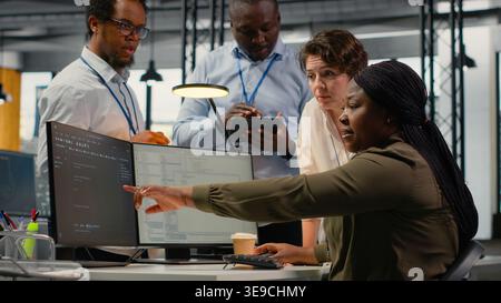 Team of software developers in office working together, automating workflows using AI. IT experts brainstorming to refine deep learning computational models for faster processing, camera B Stock Photo