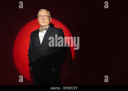 successful, experienced senior businessman isolated on red spot light background with copyspace. Personal Growth Keynote Speaker. Stock Photo