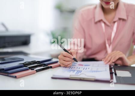 Professional woman review finance data graph analyze business report planning budget strategy desk workspace accounting Stock Photo