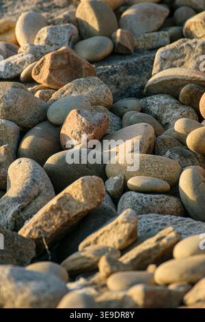 Vertical close up of smooth natural pebbles lying on a beach Stock Photo