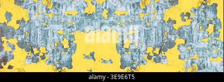 Wide grungy urban background. Old yellow painted iron texture. Metal surface with peeling cracked paint Stock Photo