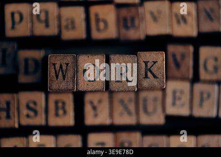 Sharp focus on the word WORK spelled with wooden blocks, featuring vibrant wood tones and textures Stock Photo