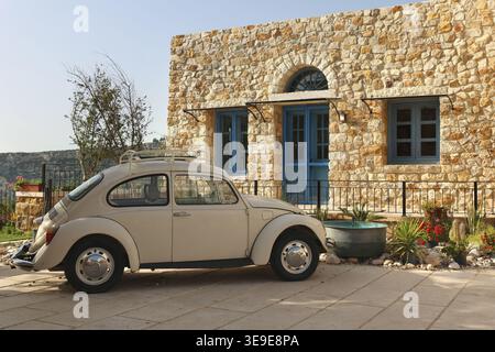 Arnaoon, Lebanon - March 28, 2024: Volkswagen car parked in front of a rustic Lebanese stone house, capturing a blend of classic architecture and ever Stock Photo