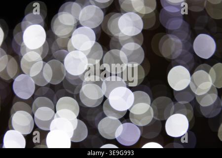 Abstract white and grey bokeh lights on a dark background Stock Photo