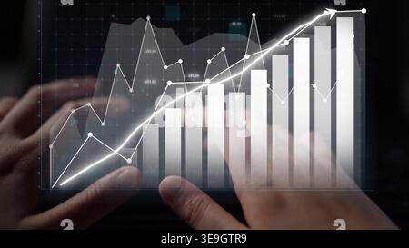 A business professional engages with financial data on a digital platform, focusing on a growth graph. This image highlights the intersection of Stock Photo
