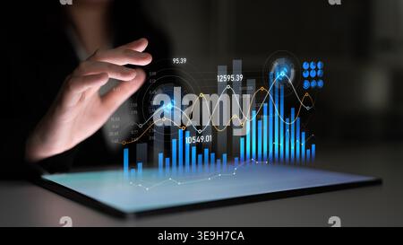 A professional businessperson interacts with a high-tech tablet interface showcasing dynamic graphs and charts. The modern workspace reflects Stock Photo