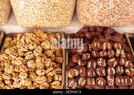 Walnuts, dried fruits, and seeds displayed at Siab Bazaar in Samarkand. Traditional Uzbek market stall showcasing nuts and dried fruit confections in Stock Photo