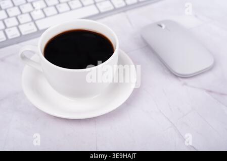 Cup of coffee and computer mouse on a desk Stock Photo