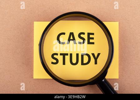 Magnifying glass and case study text on adhesive note Stock Photo