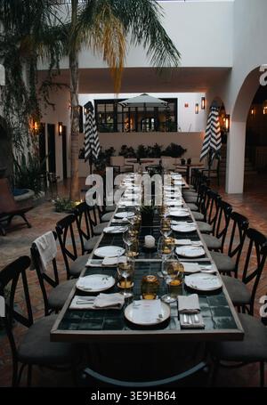 Long table set up for a large dining part, in open air dining room. Stock Photo