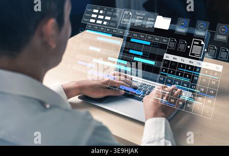 Man Using Laptop with Advanced Project Management Software, Virtual Interface with Charts, Calendar, and Task List in Modern Office Environment Gantry Stock Photo
