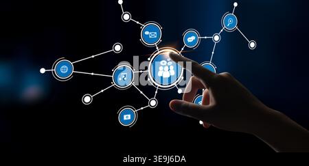 A human hand interacts with digital icons on a dark background, symbolizing networking, communication, social interaction, and modern technology Stock Photo
