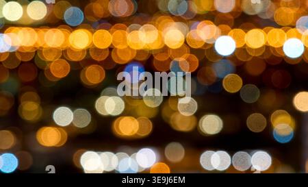 Abstract background of golden and blue city night lights in soft bokeh. Warm glowing circles create a festive and magical atmosphere. Stock Photo
