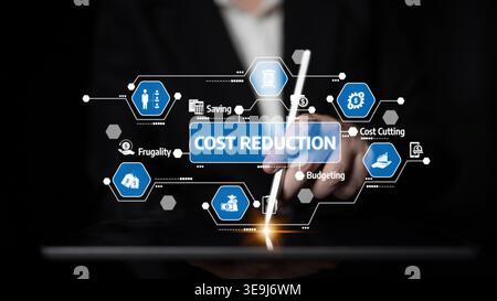 Businessman interacts with a tablet showcasing cost reduction strategies, emphasizing icons of saving, budgeting, and frugality in a modern digital Stock Photo