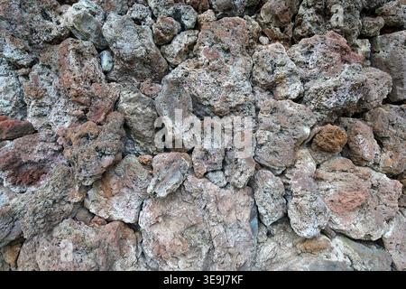 Texture of a wall made of porous volcanic rocks in various shades of grey and brown. Natural stone background, Canary Islands. Stock Photo