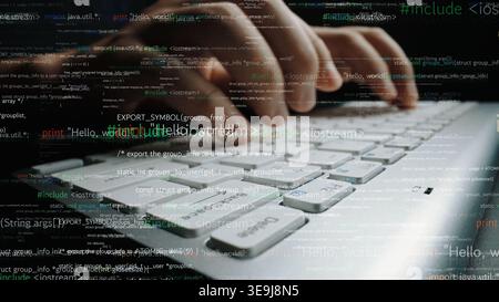 Close-up view of hands typing on a laptop keyboard surrounded by coding text, representing the world of technology and programming innovation in a Stock Photo