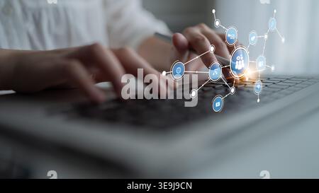 A close-up view of a person typing on a laptop, surrounded by digital icons and networks, illustrating the modern concept of communication and Stock Photo