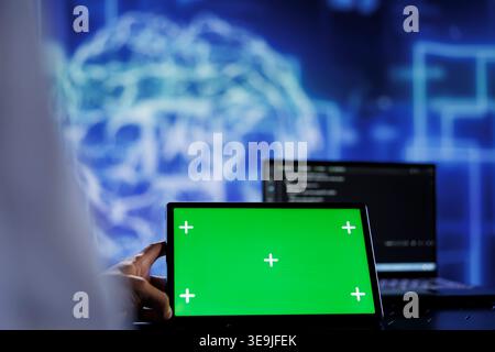 Trained admin writes code on mockup tablet to visualize artificial intelligence neural networks using augmented reality. High tech workspace worker runs AI script on isolated screen device Stock Photo