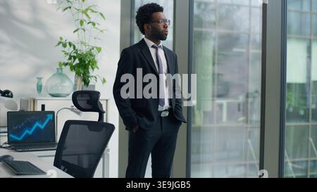 Pensive African American business man thinking in office looking out window create solution ethnic businessman male professional think idea decide Stock Photo