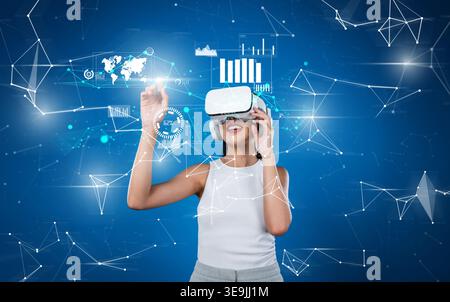 A woman wearing a VR headset interacts with vivid digital graphics representing data analysis and financial insights, embodying the future of Stock Photo