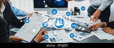 A dynamic business team engages in collaboration, analyzing data, and discussing digital strategies in a modern office filled with charts, reports Stock Photo