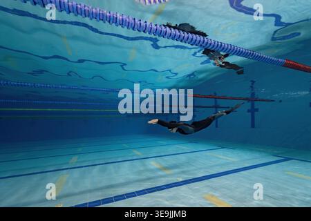 Female Athlete Training Underwater in Wetsuit – Pool Fitness Photography Stock Photo