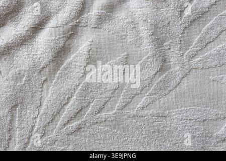 Close-up of soft white terry cloth towel with raised embossed leaf pattern and textured looped surface background Stock Photo