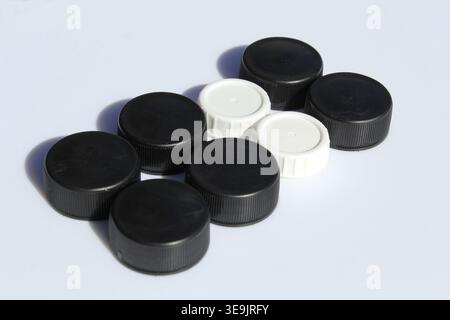 Black and white plastic bottle caps on a white background Stock Photo